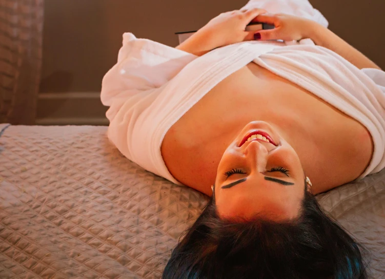 a woman with a hairy  laying on top of a bed