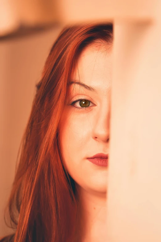 a woman with red hair looks over the edge of her face