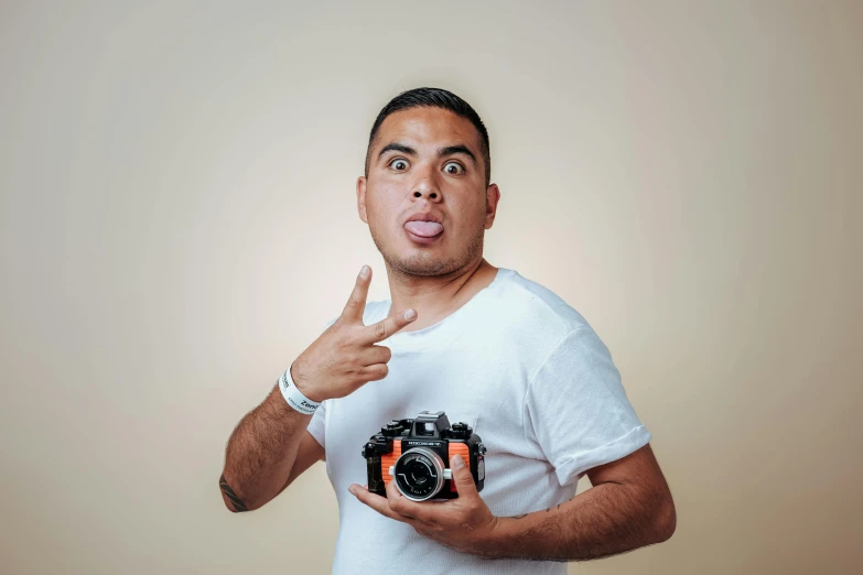 the man holds two different cameras in front of him