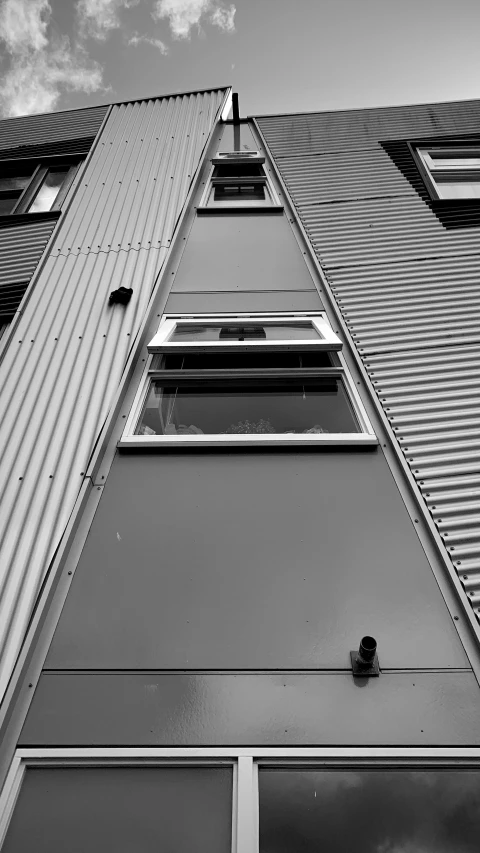 a close up of the corner of an angled building with windows