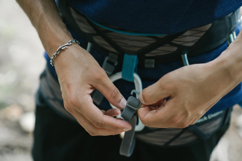 a person holding a small object while wearing celets