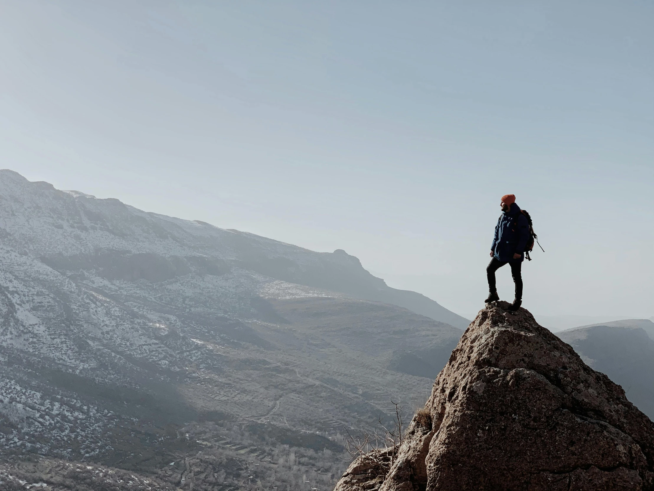 the lone person stands on top of the large rock