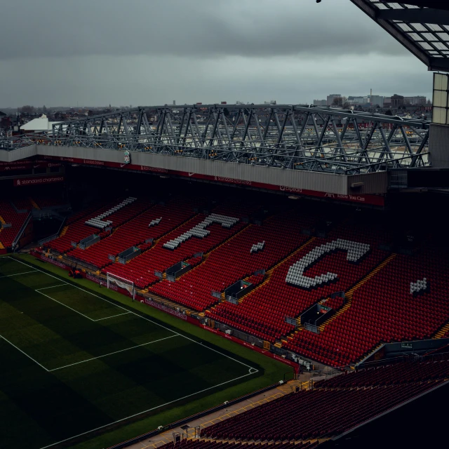 an empty stadium with some fans on the sidelines