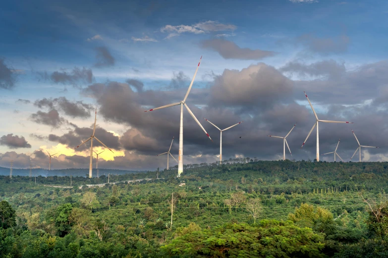 many windmills towering high on a green hillside