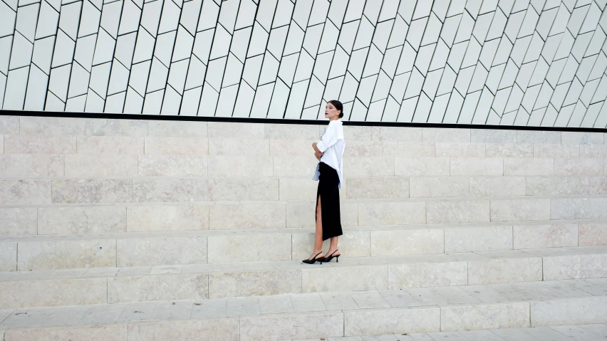 a woman posing in front of a wall