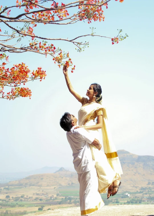 a man standing next to a woman under a tree