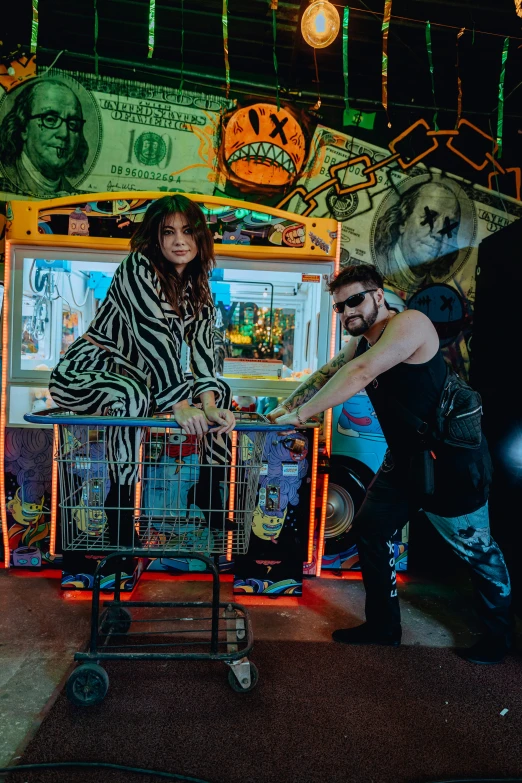 two people are in front of a brightly lit carnival