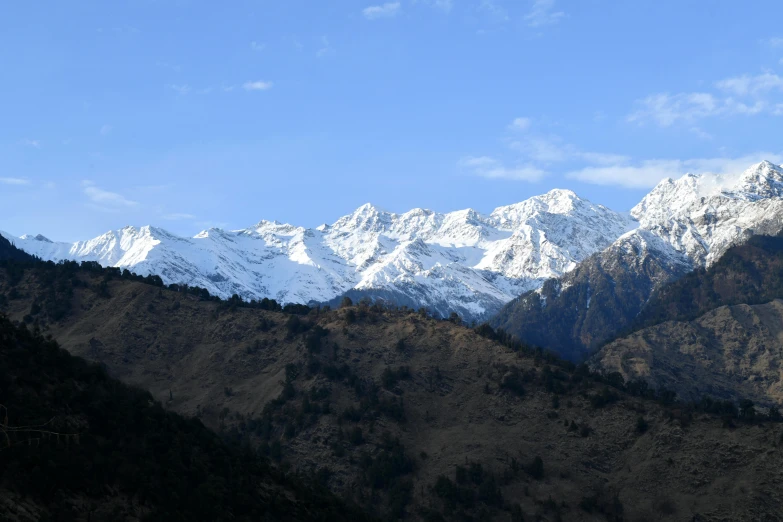 a snow covered mountain range with trees around