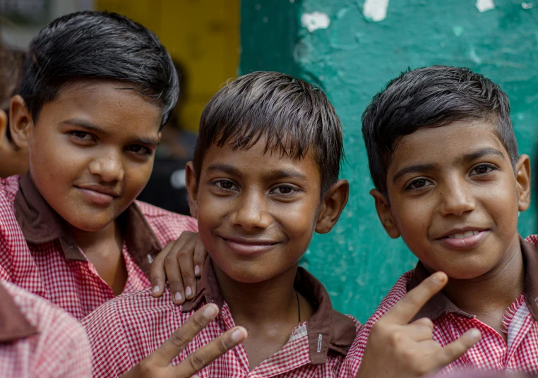 three small boys that are standing up for a po