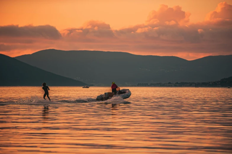 two people on their water skis walking towards a speed boat