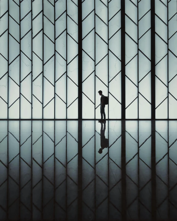 a man in a suit walks through the shadows in front of a building