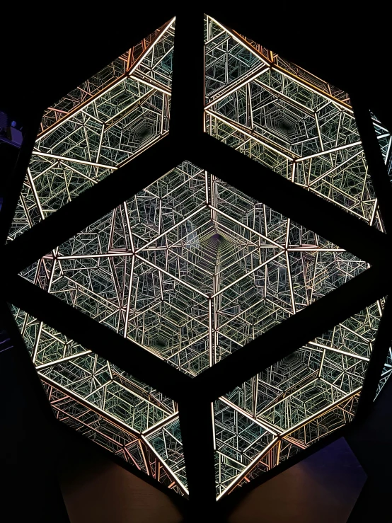 an intricate geometrical sculpture sits in the dark