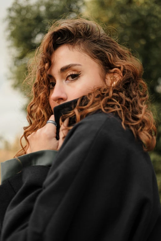 a close up of a person holding a cellphone near their face