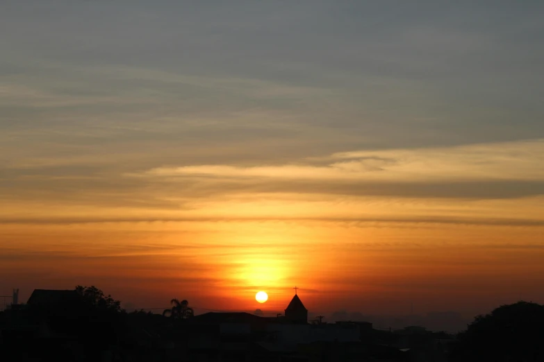 the sun is setting over a town and some buildings