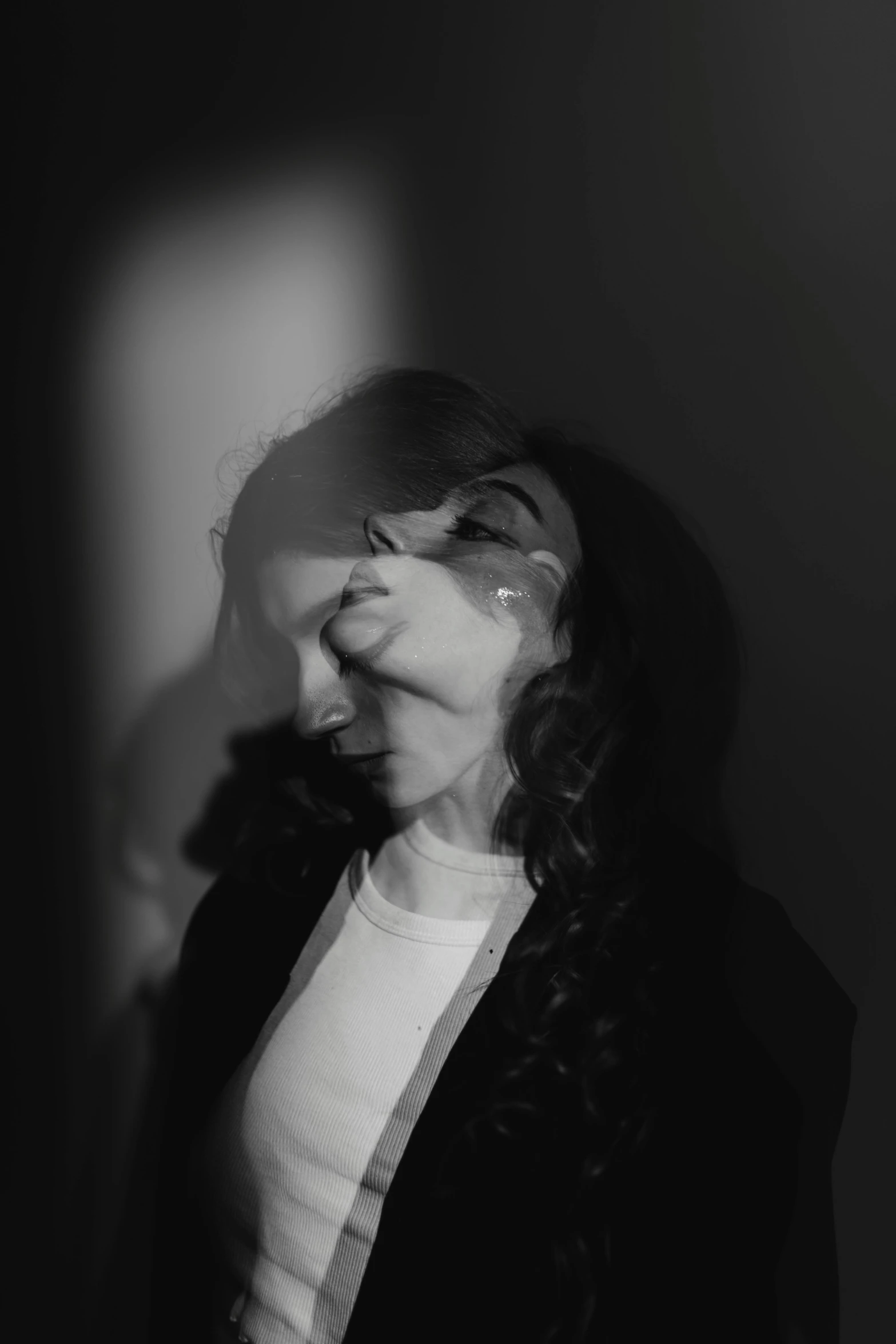 a woman in the dark covering her eyes