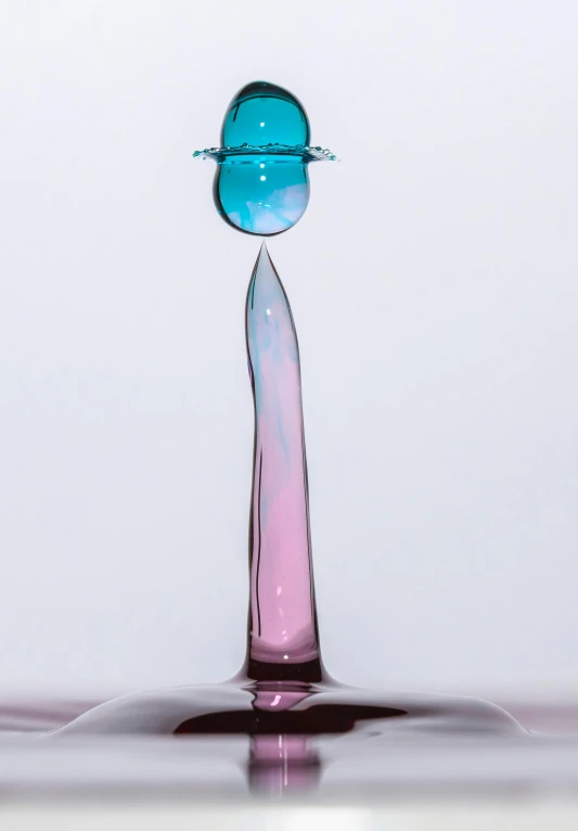 an unusual liquid drop that has blue and pink bubbles