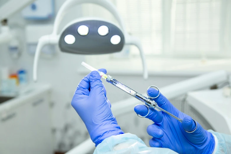 a person in a hospital operating room holding a syquet