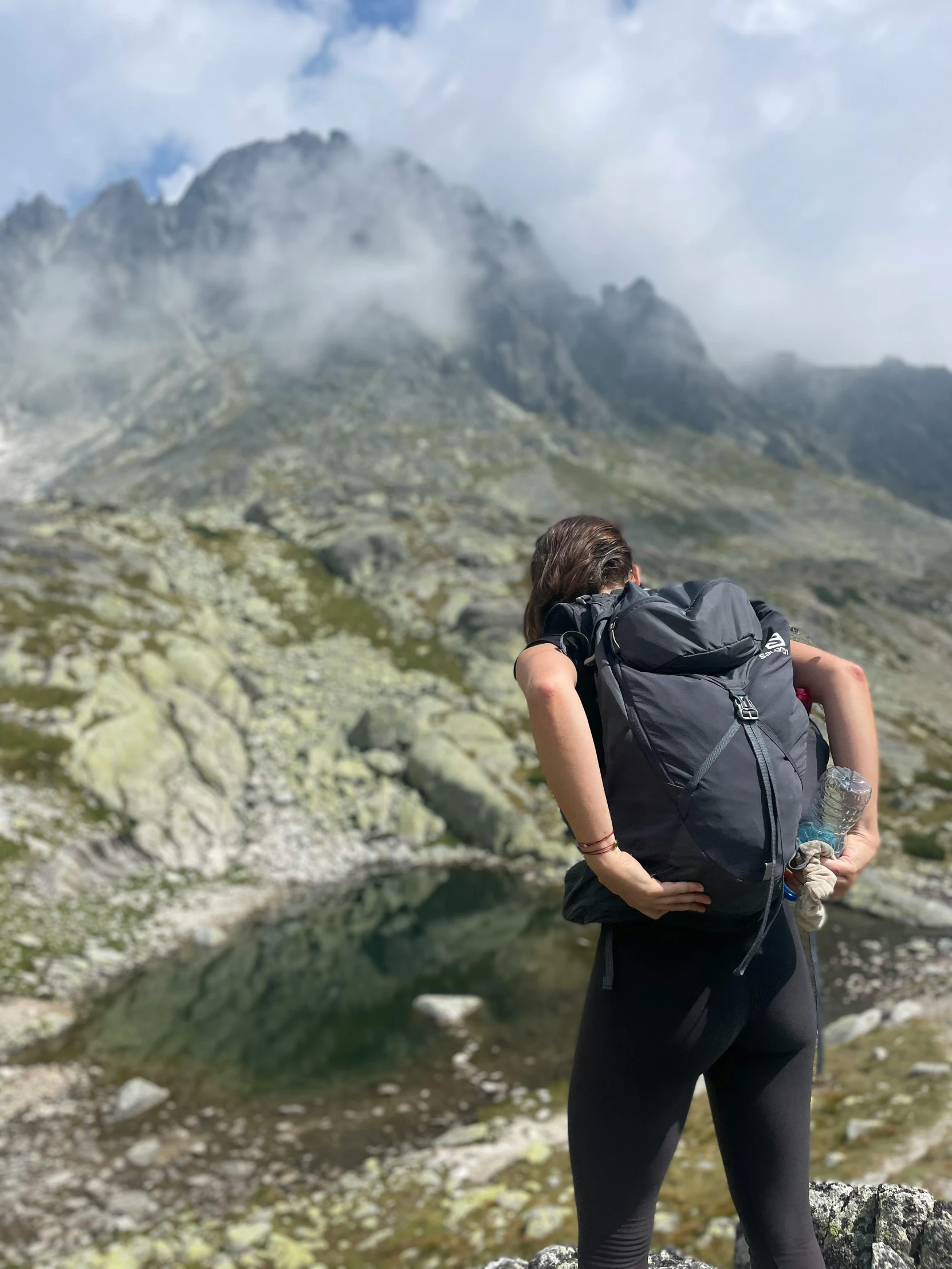 a woman on top of a mountain with backpack