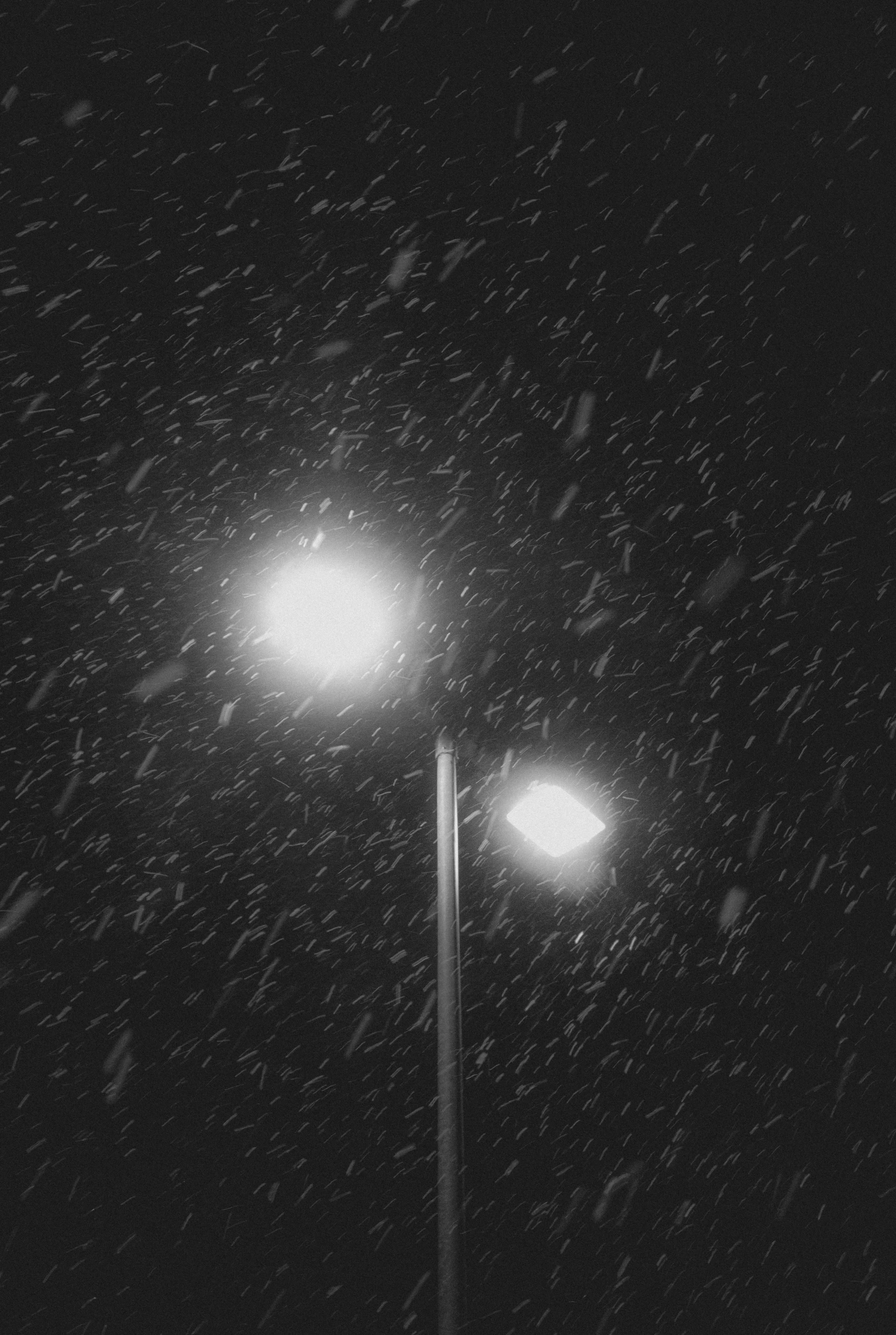 street lights with snow on them in the night sky