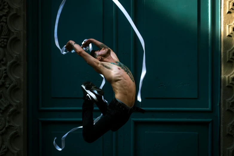 a man on a pole holding onto some white ribbons