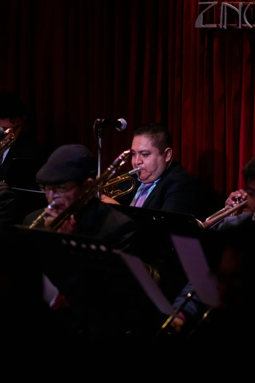 men playing trombones, singing and performing on stage