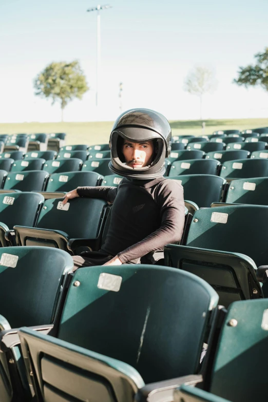 a man wearing a helmet standing next to some chairs