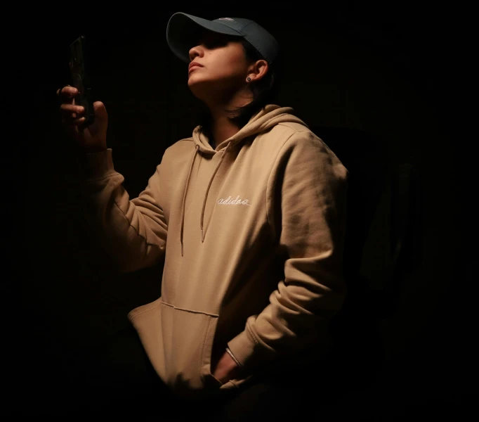 a woman in a hoodie holding her cell phone