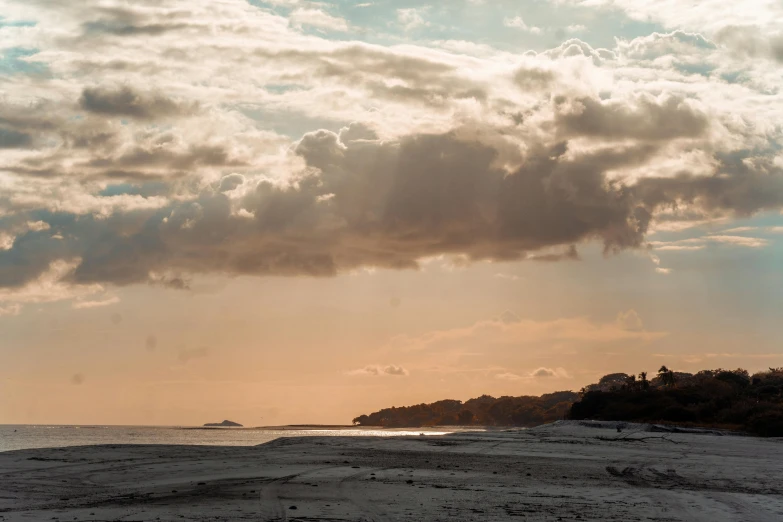 a sunset over the beach and shore with a boat in it