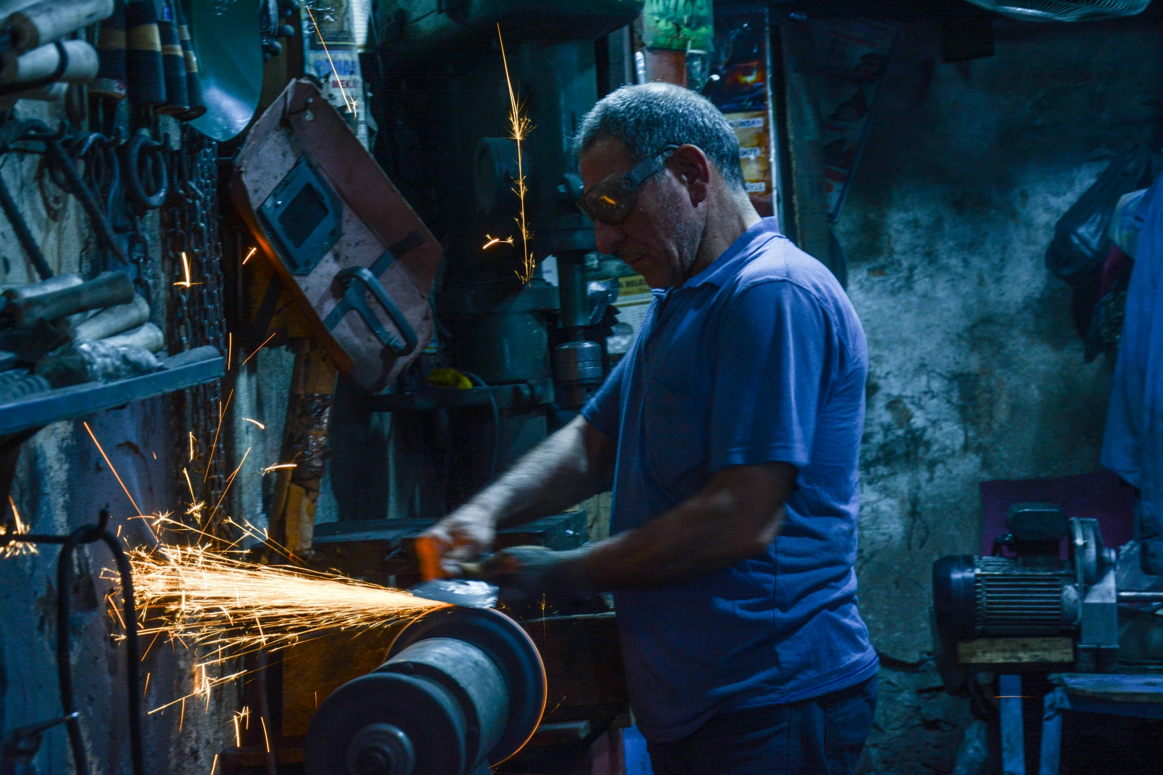 a man in blue shirt grinding a steel