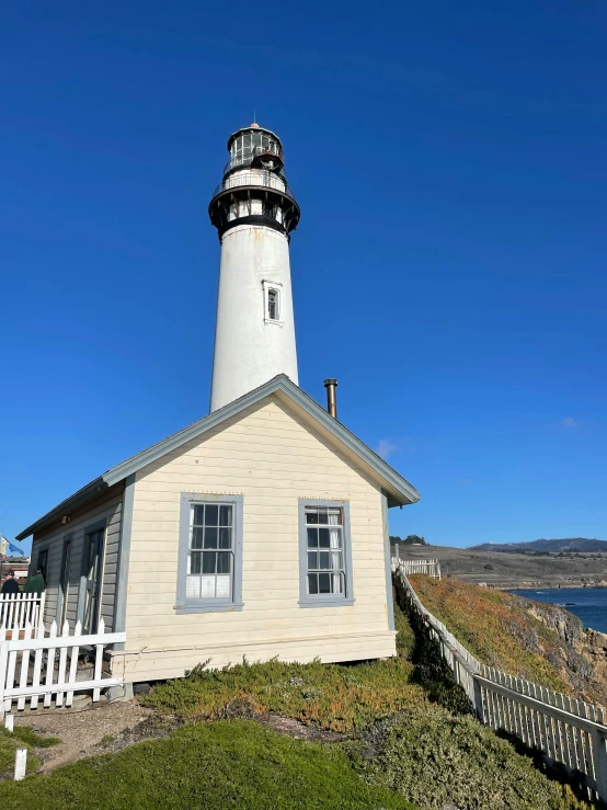 a small white building with a light house on the top