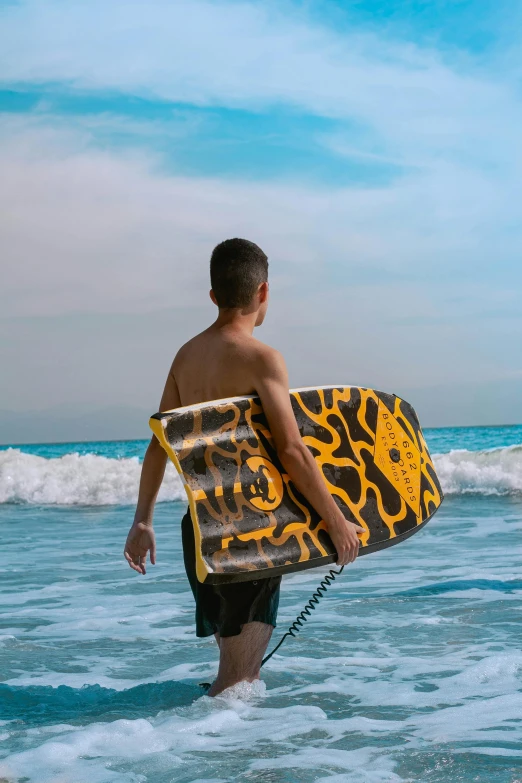 a man carrying a surfboard while walking into the ocean