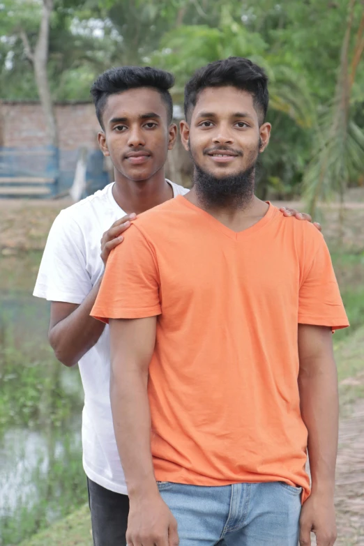 two men who are standing in front of a body of water