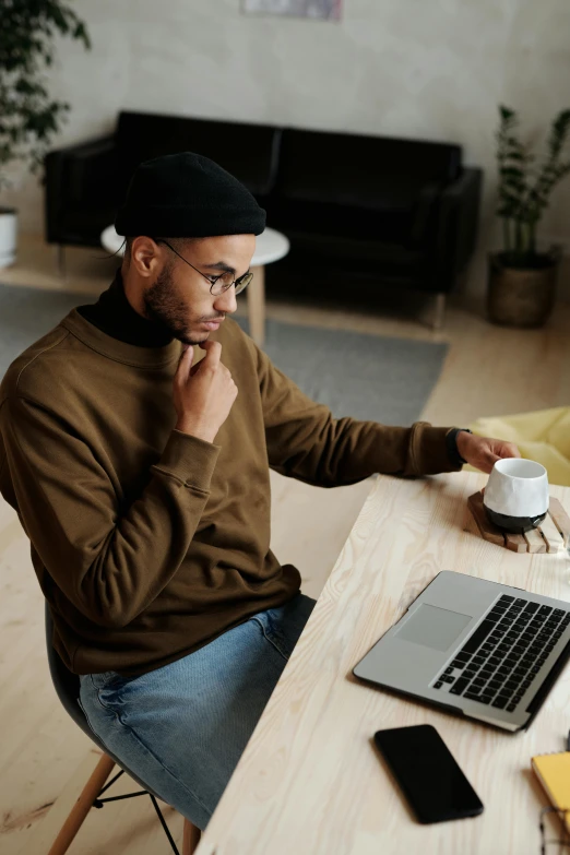 a man is using his laptop and talking on the phone