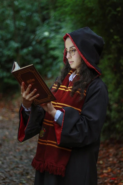 a girl dressed in medieval clothes holding a book