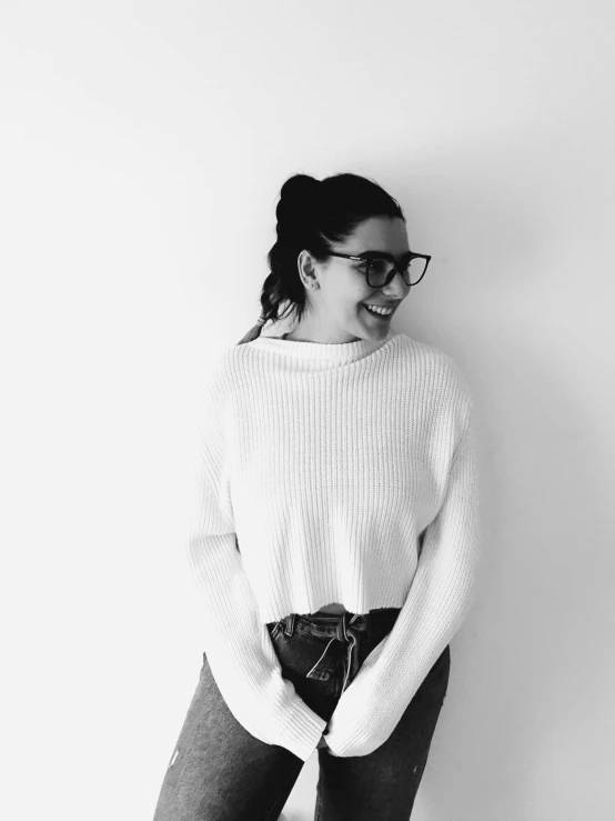 a woman standing against a wall smiling