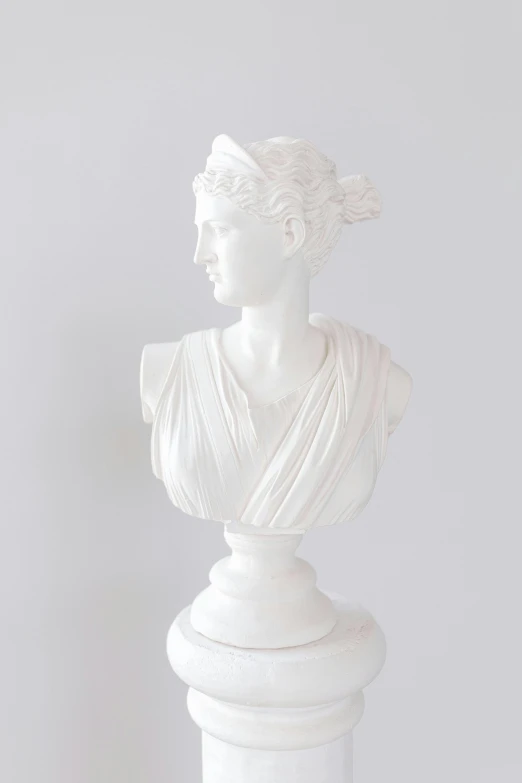 a marble bust of a woman holding her hair