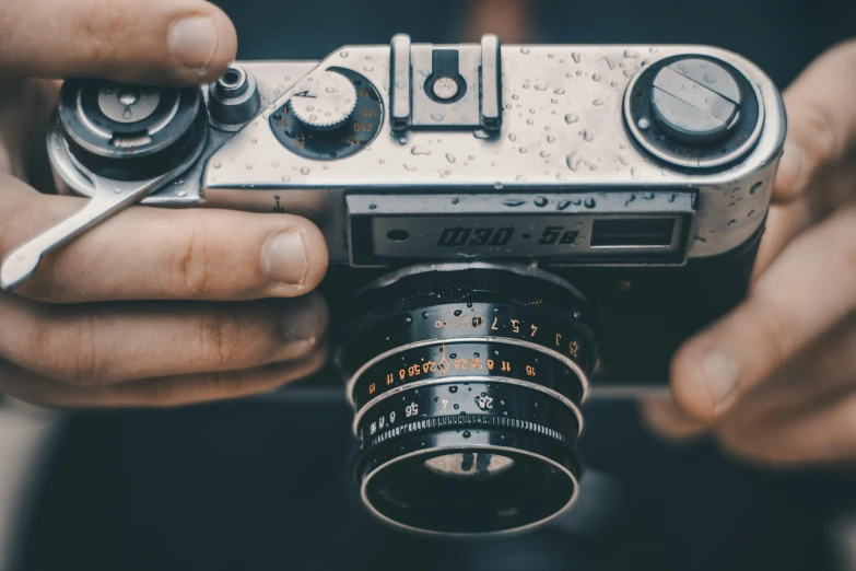 a person holding an old style camera up