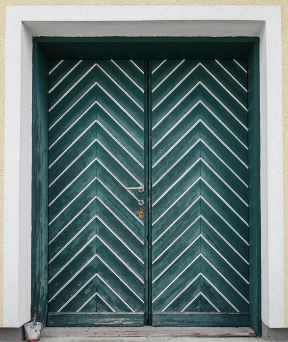 a green and white door with an ornate design