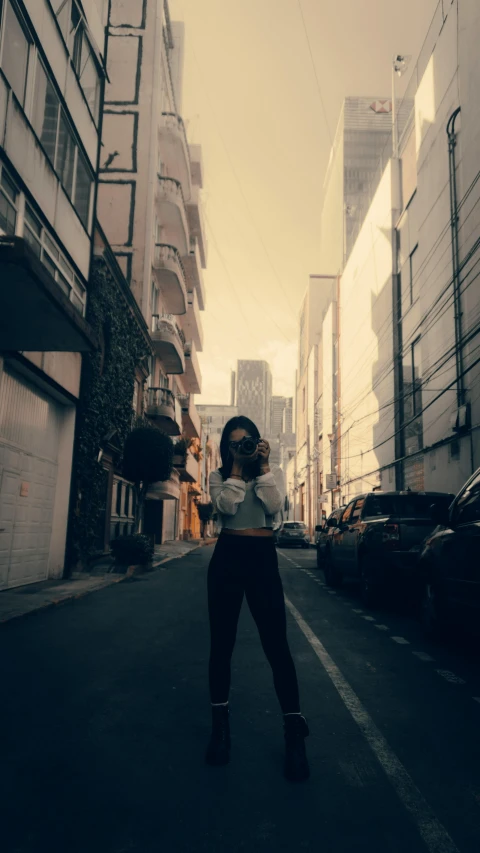 a woman stands on the side walk of a city street