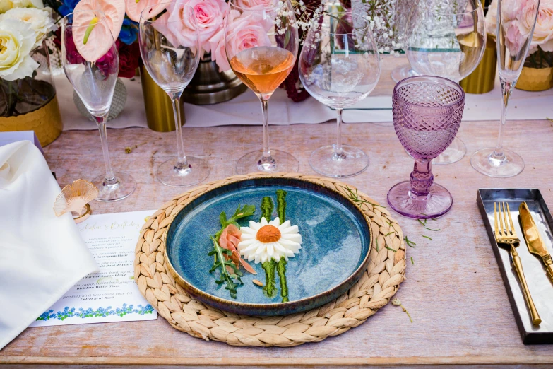 table with a plate on top, wine glasses and plates