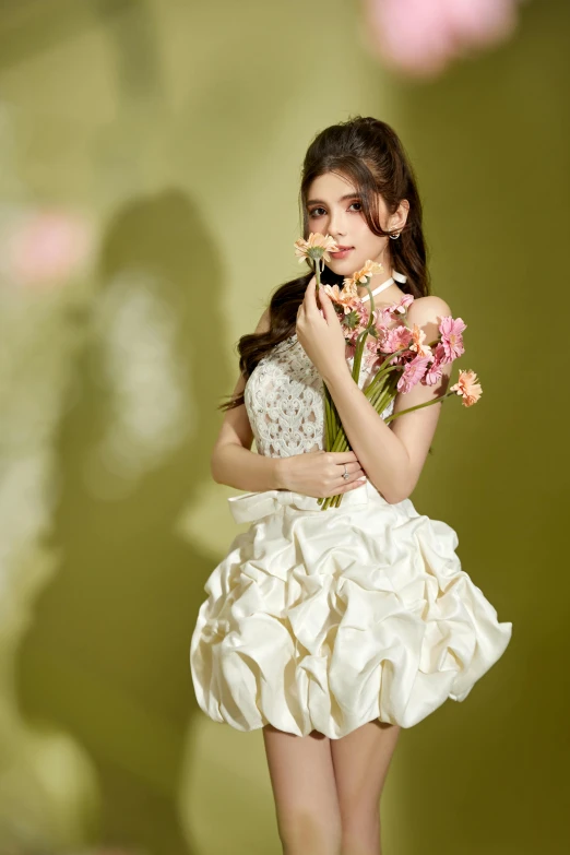 a woman holding a flower is wearing a dress