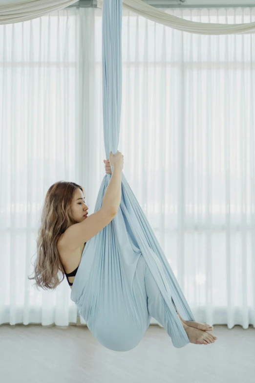 a woman is stretching in a hammock