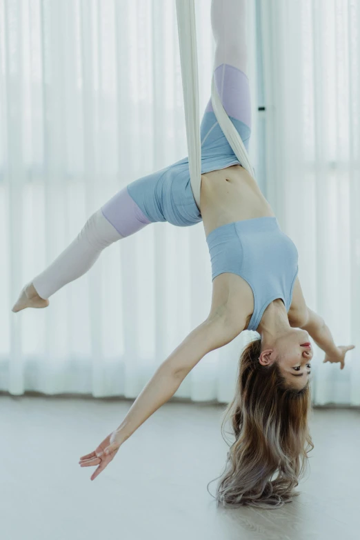 a young woman performs a handstand on a floor