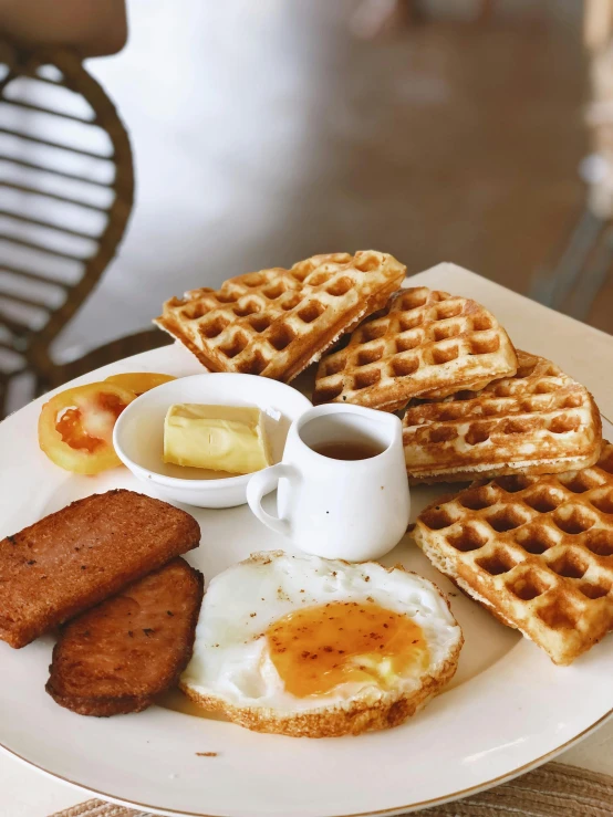 there is waffles, eggs, er and syrup on the plate