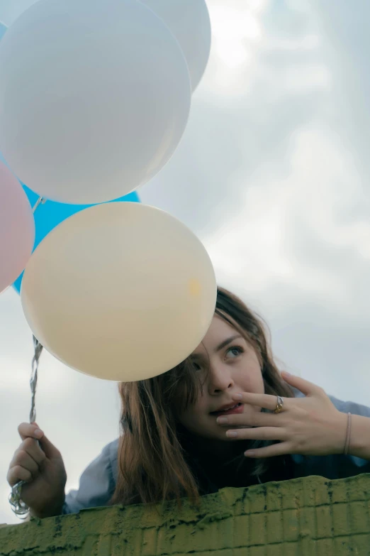 a girl with a bunch of balloons tied to her face