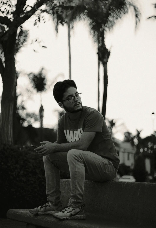 a man crouches on a ledge, his hands resting his knees