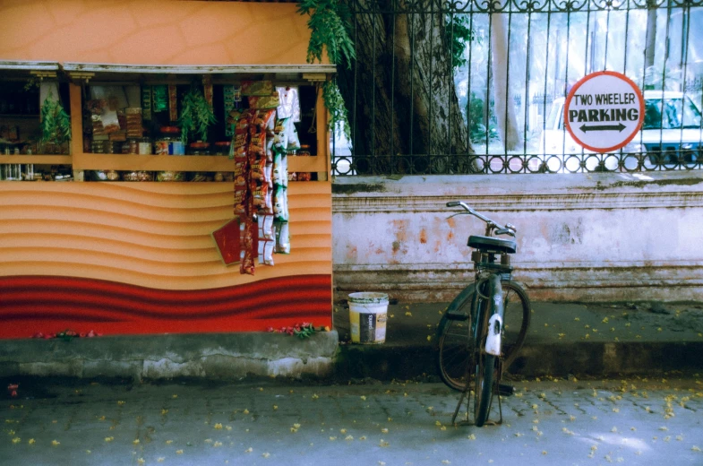 a bicycle parked outside a vendor next to an orange building