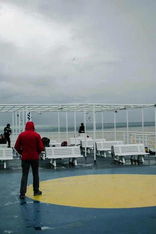 people sitting on benches watching soing in the ocean