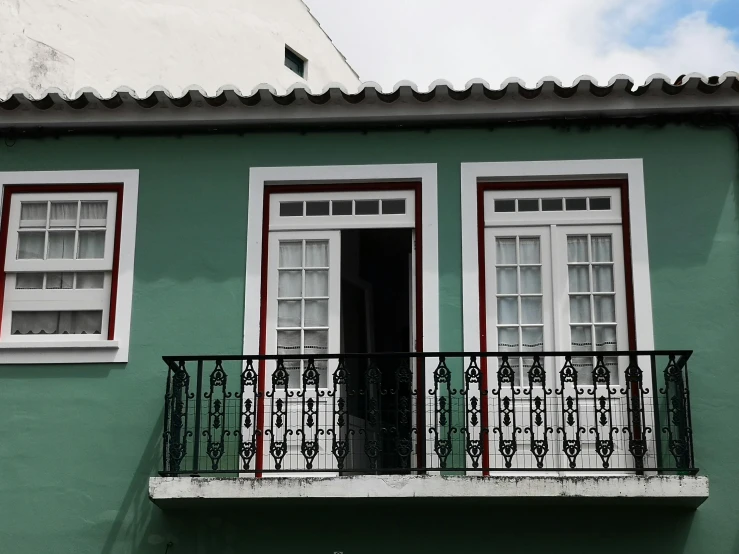 a balcony and balcony railing are painted green