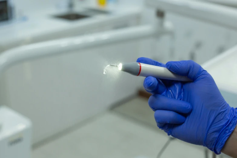 a person wearing gloves and latex holding an electronic cigarette